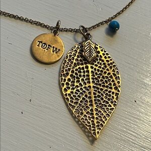 Filigree leaf pendant with a small charm engraved TOFW and small blue bead 28”